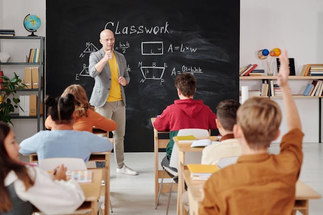 a math teacher standing in front of a class of students